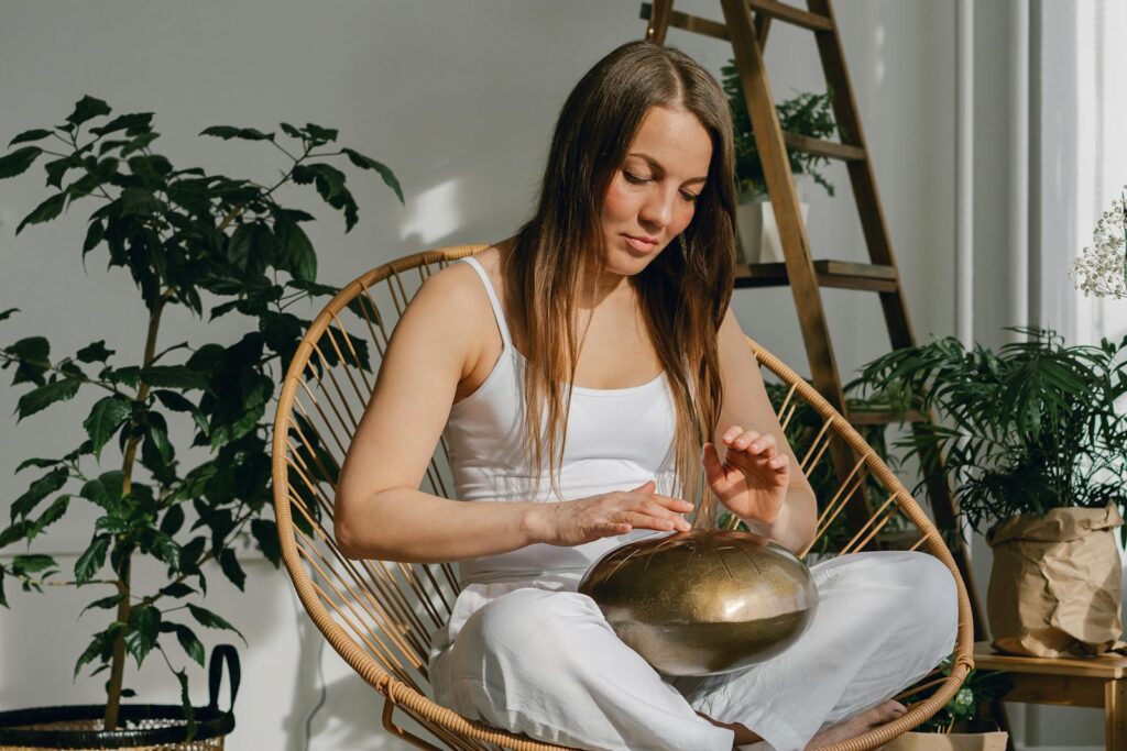 Young woman playing on steel tongue drum