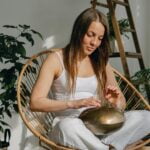 Young woman playing on steel tongue drum
